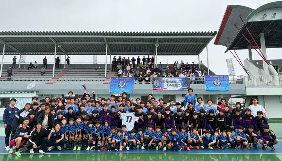 スタジアムに全カテゴリーの選手と応援に集まった人たちが並ぶ集合写真